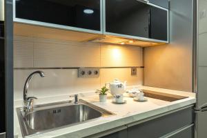 a kitchen with a stainless steel sink and cabinets at El Refugio de Emma in Seville