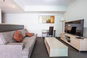 - un salon avec un canapé et une table dans l'établissement Brisbane Casino Tower Luxury Suites, à Brisbane