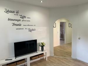 a living room with a flat screen tv on a wall at Ferienwohnung im Wesertal in Hameln