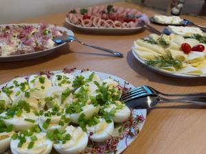 a table topped with plates of food with eggs at Hotel Krasnoludki in Sosnówka