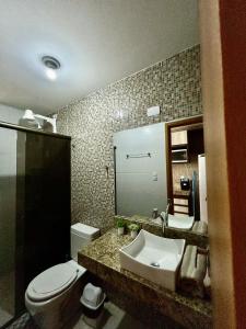 bagno con lavandino, servizi igienici e specchio di Ap com localização Privilegiada - Com Ar a Campina Grande