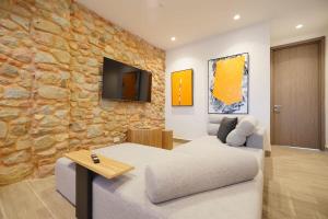 a living room with a couch and a stone wall at Stunning 1BR in Casco Viejo in Panama City
