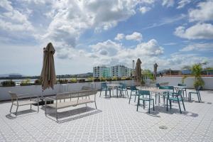 a patio with tables and chairs and umbrellas on a roof at Stunning 1BR in Casco Viejo in Panama City