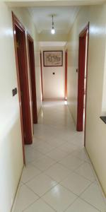 een lege hal met twee deuren en een tegelvloer bij Appartement agadir centre in Agadir