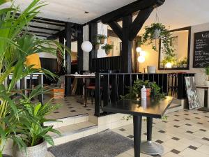 um restaurante com plantas e uma mesa num quarto em Hotel Café Rhönperle em Bad Neustadt an der Saale