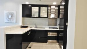 a kitchen with black and white cabinets and a sink at DAMAC - Bays Edge In Business Bay in Dubai