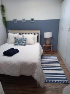 1 dormitorio con 1 cama grande y pared azul en 28 Kabeljauws, en Jeffreys Bay