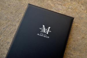 馬里博爾的住宿－馬里博爾城市公寓酒店，坐在桌子上的一个黑书