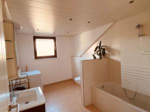 uma casa de banho com um lavatório, uma banheira e um WC. em Ferienwohnung Angelina em Tiefenbach