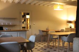 ein Zimmer mit Tischen und Stühlen sowie einer Küche in der Unterkunft La Chaumière Normande 
