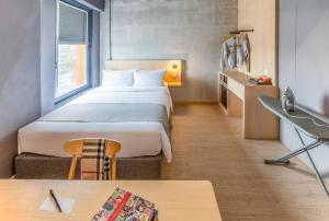 um quarto de hotel com uma cama grande e uma secretária em BRIX KLIA By Pinetree em Sepang