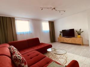 a living room with a red couch and a tv at Ferienwohnung Angelina in Tiefenbach