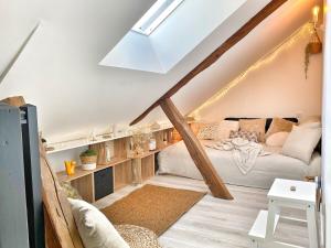 a attic room with a bed and a couch at Le repère des sommeliers - Sejour a Auxerre in Auxerre