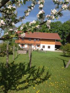 una casa in mezzo a un campo con alberi di Urlaubshof Grimm a Egling