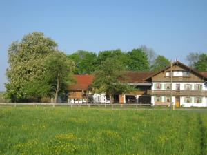 una grande casa con un campo di fronte di Urlaubshof Grimm a Egling