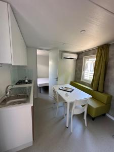 een keuken en een woonkamer met een tafel en een bank bij Campeggio Madonna Del Ghisallo in Magreglio