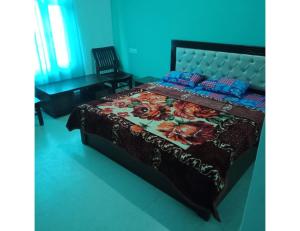 a bedroom with a bed with a floral bedspread at Ashgrove village resort, Kempty fall in Lakhwār