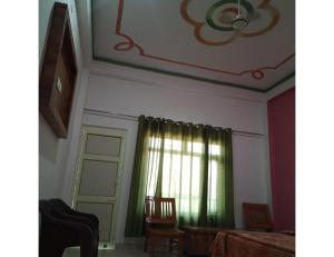 a room with a window with a green curtain at Ashgrove village resort, Kempty fall in Lakhwār