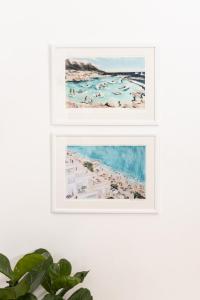 two framed prints of a beach with people in the water at Boho Chic Studio Stellenbosch in Stellenbosch