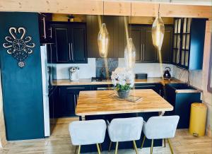 a kitchen with a wooden table and white chairs at Villa Alexandra in Kościelisko