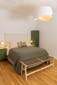 a bedroom with a large bed and a bench at Boho Chic Studio Stellenbosch in Stellenbosch