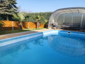 a large blue swimming pool next to a house at Villa Nova in Hévíz