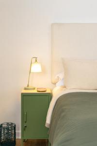 a bed with a green night stand with a lamp on it at Boho Chic Studio Stellenbosch in Stellenbosch