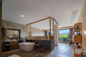 um banheiro com banheira e um espelho grande em Wang Yun Residence Boutique Homestay Zhangjiajie em Zhangjiajie