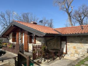 a house with a table and chairs in front of it at Casa Rilassa Monte in Cividale del Friuli