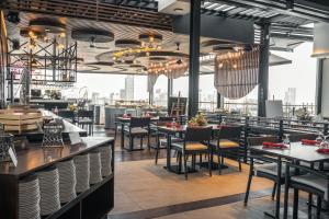 a restaurant with tables and chairs and a large window at Yello Hotel Cebu powered by Cocotel in Cebu City