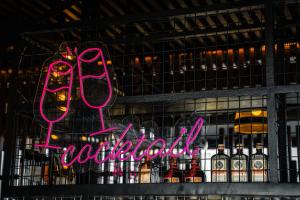 a neon sign that says hot chocolate next to bottles of alcohol at Yello Hotel Cebu powered by Cocotel in Cebu City