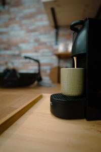 une cafetière assise au-dessus d'une table dans l'établissement Le Pèlerin, à Mons