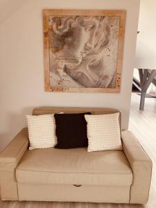 a couch in a living room with a painting on the wall at Betongold Studio Wohnung in Duisburg