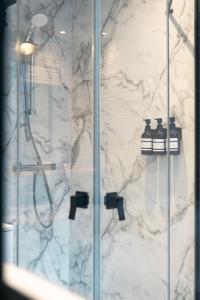 a bathroom with a shower with a marble wall at Le Pèlerin in Mons