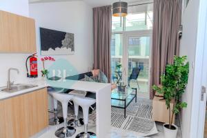 uma cozinha com uma mesa de vidro e algumas plantas em Modern 1 Bedroom In Oasis2 em Abu Dhabi