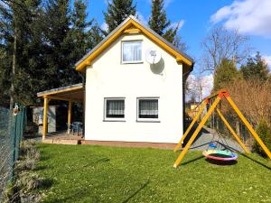 uma casa com um parque infantil em frente em Holiday House Lawendowa Przystań em Miszkowice