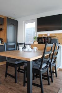 a kitchen and dining room with a wooden table and chairs at Hausboot - Nordsonne 11 in Wangerland