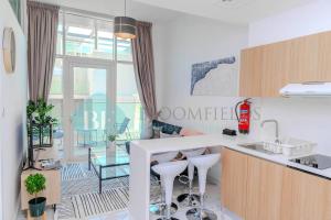 una cucina con bancone e sgabelli in una stanza di Deluxe 1bedroom In Oasis 2 a Al Qurayyah