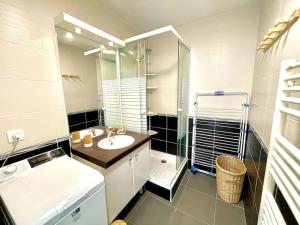 a bathroom with a sink and a shower and a mirror at Très joli T2 en face du plan d'eau d'ETEL in Étel +28 photos