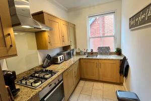 eine kleine Küche mit Herd und Spüle in der Unterkunft The Westborough Willows by Grandeur Property in Wimborne Minster + 1 Foto