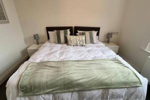 a bedroom with a large bed with white sheets and pillows at NEW! Sleeps 4, Wimborne Centre, Parking & Wi-Fi - The Westborough Willows in Wimborne Minster