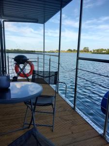 einen Tisch und Stühle auf einem Boot auf dem Wasser in der Unterkunft Hausboot - Nordsonne 11 in Wangerland