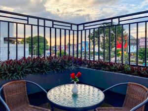 una mesa con un jarrón de flores en el balcón en favehotel Palembang, en Palembang