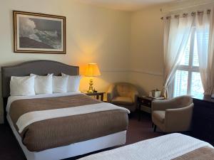 um quarto de hotel com uma cama e uma cadeira e uma janela em Kennedy House em Saint Andrews