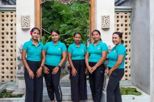 a group of women in blue shirts standing in front of a building at Villa Sky Dancer - Bali in Amed