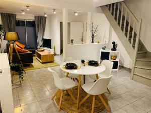 sala de estar con mesa blanca y sillas en Très belle maison d’hôte de 2 chambres à Obourg, en Mons