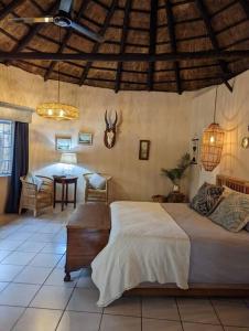 um quarto com uma cama e uma mesa num quarto em Home away from home. Experience our farm luxury. em Tzaneen