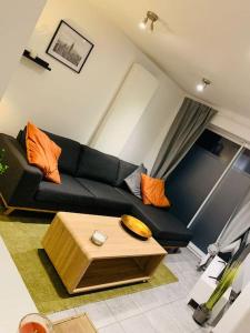 モンスにあるTrès belle maison d’hôte de 2 chambres à Obourgの黒いソファとテーブルのあるリビングルーム