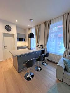 a kitchen and living room with a counter and chairs at Lovely Apartment in Fürth nähe Hauptbahnhof in Fürth