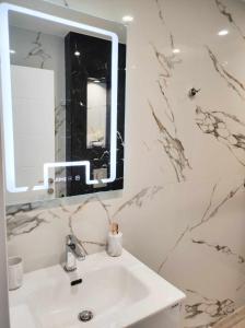 een badkamer met een wastafel en een spiegel bij DiP HOME APARTMENTS in Pomorie